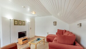 A living room with a television, sofa, coffee table, and framed pictures on the wall. - Stunning home in Njivice with WiFi (Njivice)