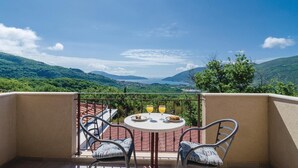 A balcony with a table and chairs overlooking a scenic landscape. - Beautiful home in Igalo (Igalo)