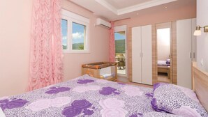 A bedroom with a bed, a wardrobe, and a balcony. - Beautiful home in Igalo (Igalo)