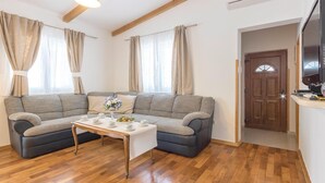 A living room with a sectional sofa, a coffee table, and a television. - Gorgeous home in Sikici (Sikici)