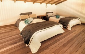 A cozy bedroom with two beds, wooden flooring, and a rustic ceiling. - Your own personal coffee farm stay in Jardin, Colombia (Jardín)