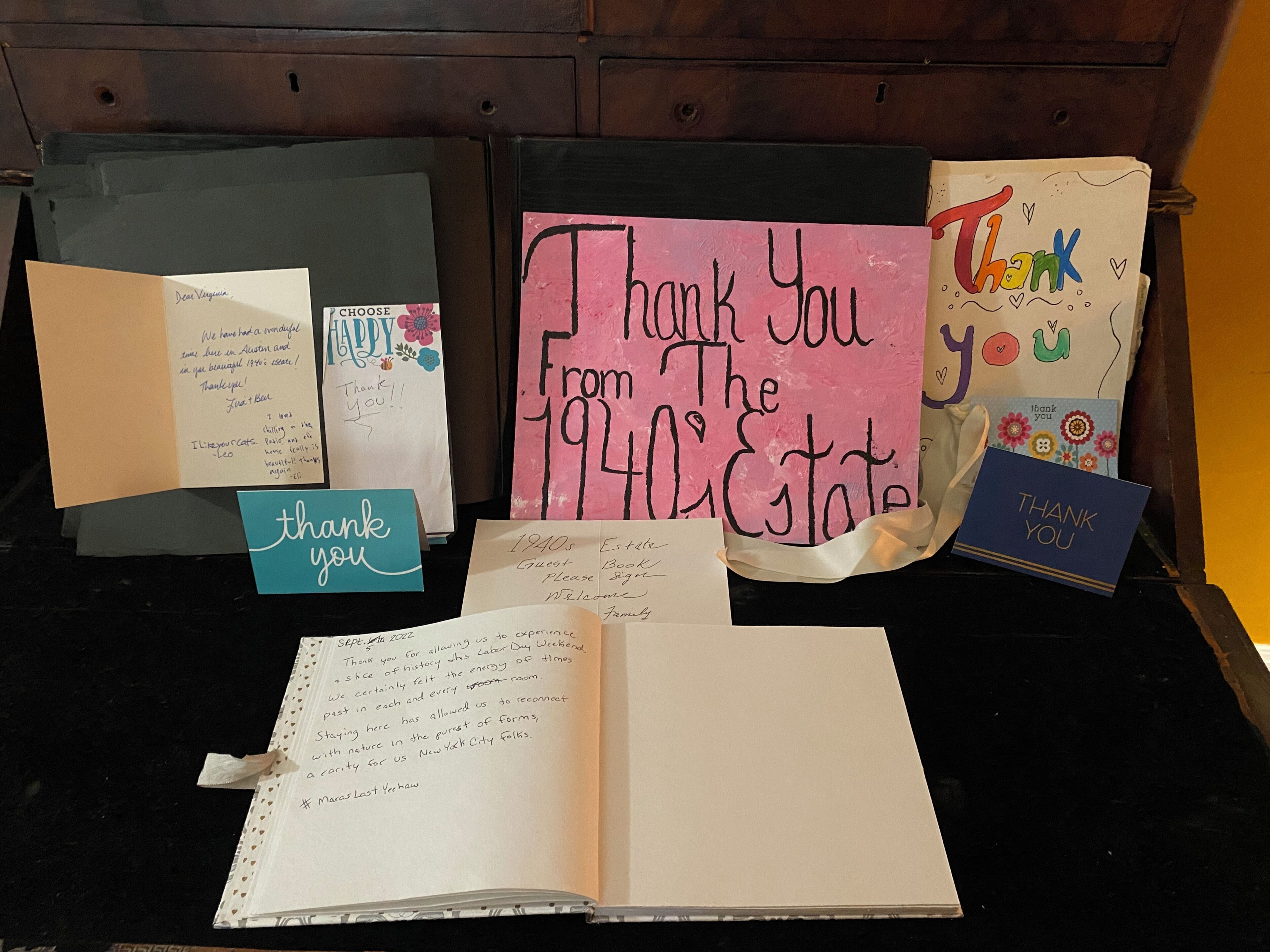 A collection of thank you cards and notes, including a handwritten note from the 1940s estate, a card with a colorful design, and a card with a blue background.