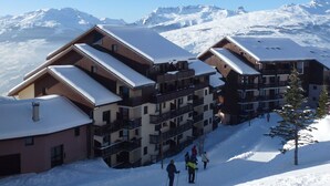 A ski resort with multi-story buildings, balconies, and a snowy mountain backdrop. - Studio in Vallandry, 4 ppl, near lifts, pets allowed (Peisey-Vallandry)