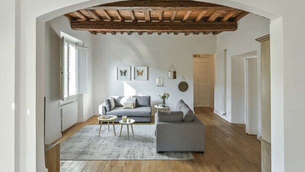 Una sala de estar con techo de madera, un sofá, una mesa de centro y una alfombra.