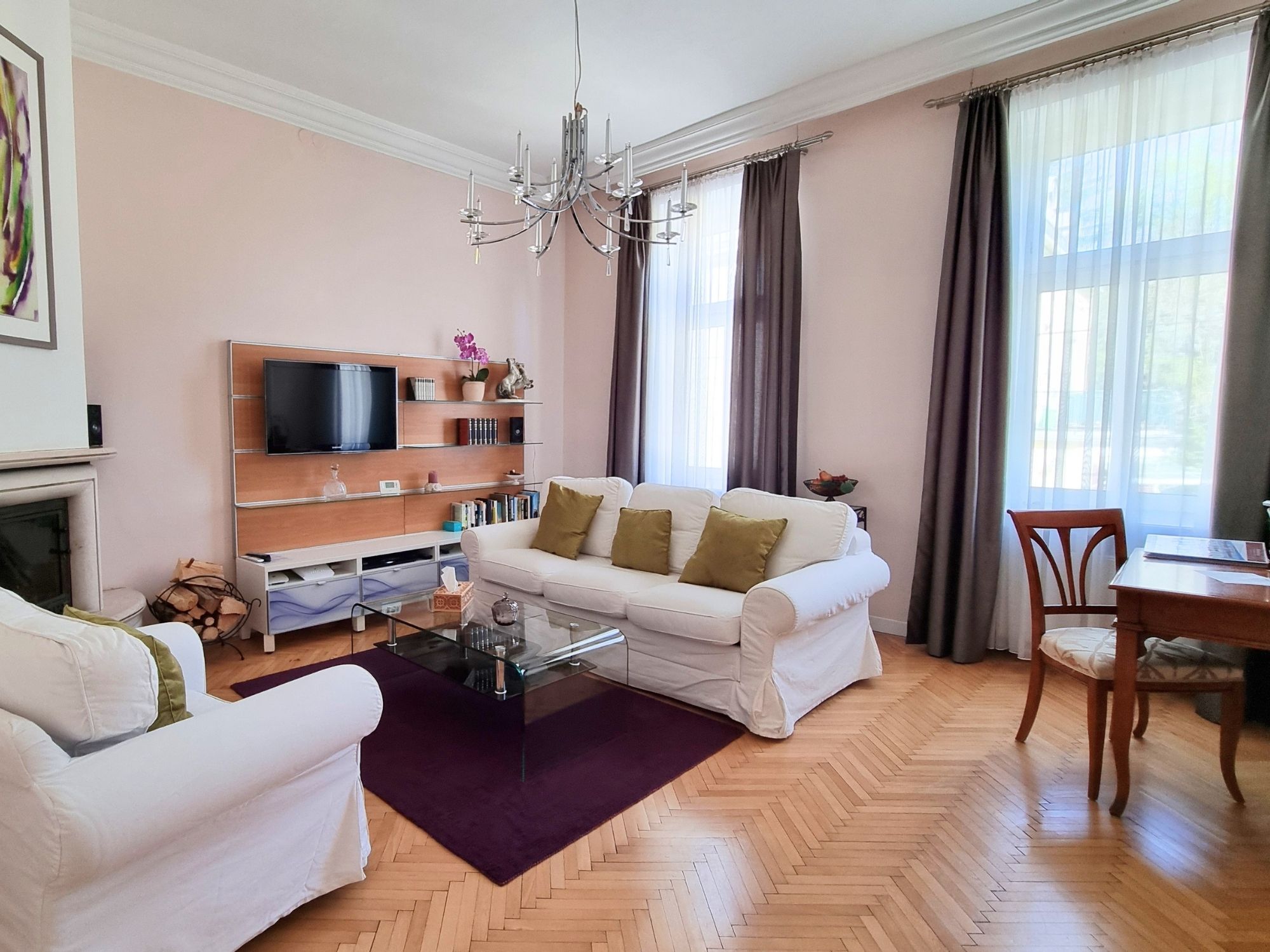 A modern living room with a sofa, coffee table, and a TV mounted on the wall.