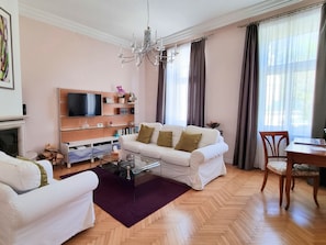 A modern living room with a sofa, coffee table, and a TV mounted on the wall.