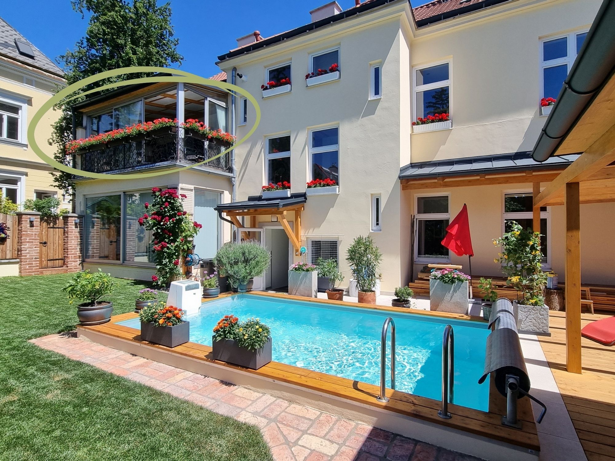 A residential property with a swimming pool, a covered patio, and a garden.