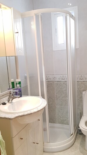 Een bad/douchecombinatie, een haardroger, een bidet, handdoeken