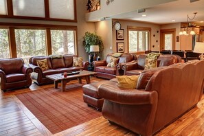 Relax in this inviting living space with leather sofas and armchairs arranged around a central coffee table.