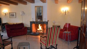 Una sala de estar acogedora con chimenea, sofás rojos y muebles de madera clásica.