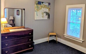 A room with a dresser, a small stool, a window with blinds, and a wall-mounted mirror. - RARE FIND - Your Own Path to Lake Erie — Historic 5-Acre Lakefront Retreat (East Springfield)