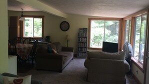 A living room with a sofa, a coffee table, a bookshelf, and a television.