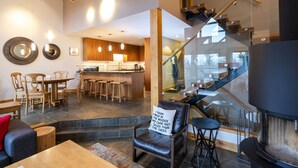 A modern interior with a bar area, seating, and a staircase.