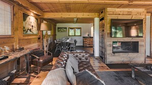 A cozy cabin interior with a dining area, a fireplace, and a sofa. - Prestigious chalet ski in ski off at Megéve (Megève)