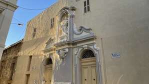 Ein Gebäude mit aufwendiger Architektur, darunter ein dekorativer Eingang und ein Schild, das eine Apotheke kennzeichnet.