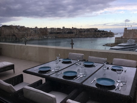 A table set for dining with a view of a historic cityscape and a body of water.