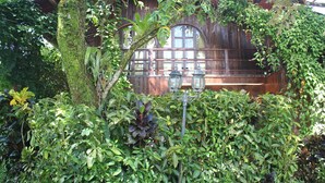 Un bâtiment en bois doté d’une grande fenêtre et d’un banc.