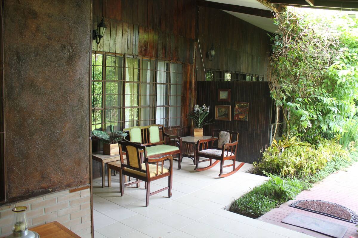 Un interior de madera tradicional con un comedor que incluye mobiliario de madera y un ventanal grande.