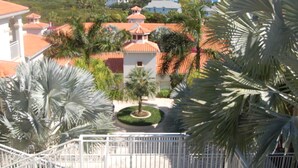 Ein Resort mit einem zentralen Gebäude, umgeben von Palmen und Blick auf den Ozean.