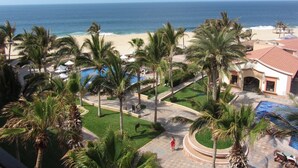 Un resort con piscina, palmeras y vistas a la playa.
