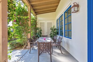 A covered patio with a table and chairs, surrounded by plants and a wooden ceiling. - Near Pool! Best Location! Single Story Poolside Villa across from Clubhouse, Pet Friendly! (C72) (La Quinta)