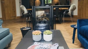 A modern living room with a glass-top table, two potted succulents, a magazine, and a black fireplace. - Luxury Holiday Home with Hot Tub,  Pet & Family friendly in the Yorkshire Dales  (Eastby)