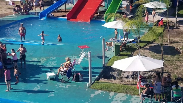 A swimming pool area with multiple slides and lounge chairs. - Mar de Sueños Parque Acuático Infantil (Parana)