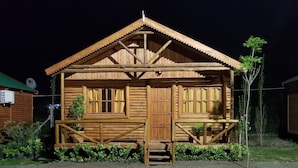 A wooden cabin with a porch, a door, and windows. - Mar de Sueños Parque Acuático Infantil (Parana)