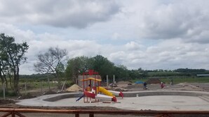 A playground with a slide and climbing structures, surrounded by a fence and trees. - Mar de Sueños Parque Acuático Infantil (Parana)