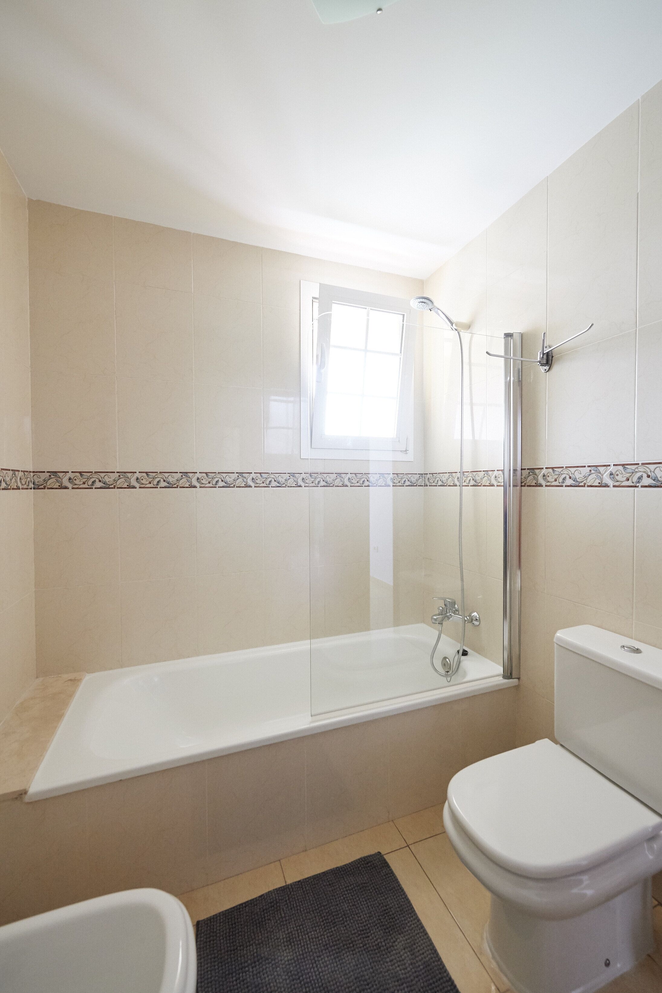 A bathroom with a bathtub, toilet, and shower.
