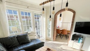 A modern living room with a sectional sofa, a wooden coffee table, and a TV.