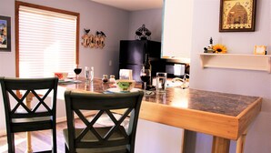 A dining area with two chairs, a table, and a kitchen in the background. -  Let the vacationing begin! (Hot Springs Village)