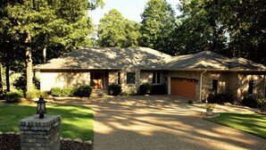 A two-story house with a front garage, a driveway, and a well-maintained lawn. -  Let the vacationing begin! (Hot Springs Village)