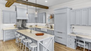 A modern kitchen with a large island, bar stools, and a built-in bench. - 'More Grayter' * Lake Views *  Walk To Beach * Gorgeous 5 BR Grayton Beach home * Neighborhood pool (Santa Rosa Beach)