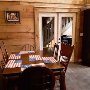 Enjoy meals in this cozy dining area with a table set for four, featuring a star and stripes pattern on the placemats.