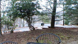 Une table et quatre chaises en métal, installées dans un jardin.