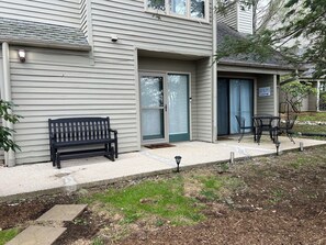 A residential building with a front porch, a bench, and a sign that reads 'SKI SLOPES.'