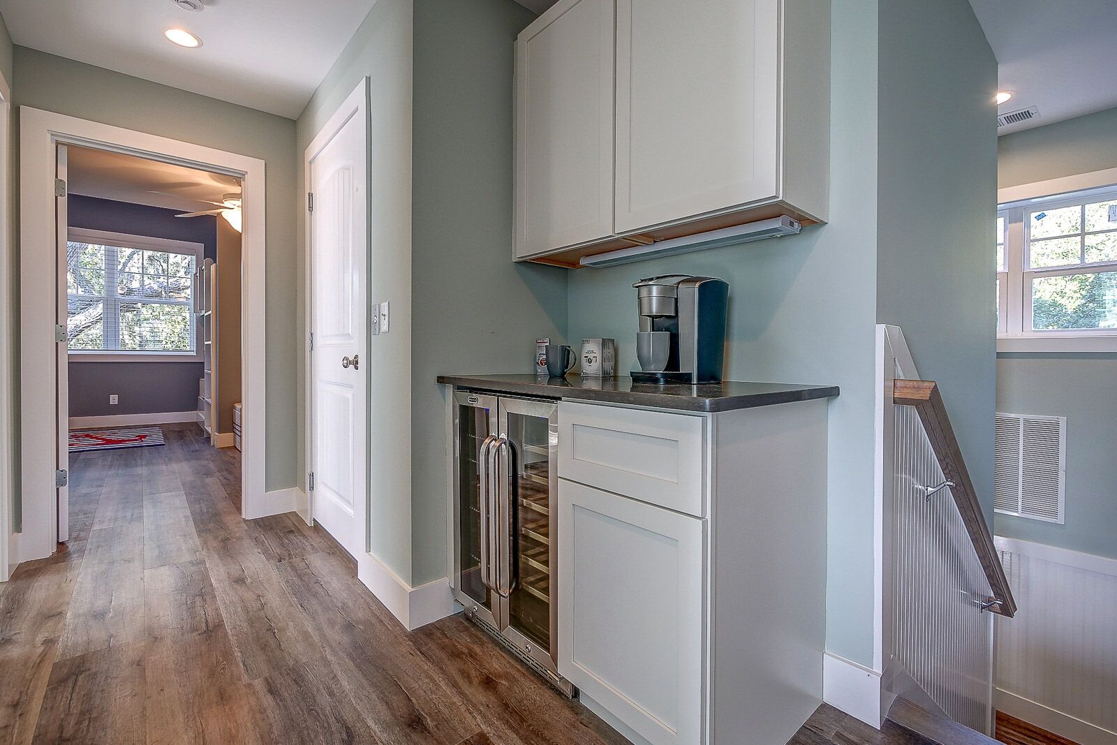 A kitchen with white cabinets, a coffee maker, and a dishwasher.