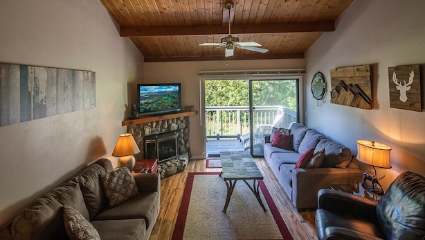 Una sala de estar acogedora con chimenea, sofás y una televisión.