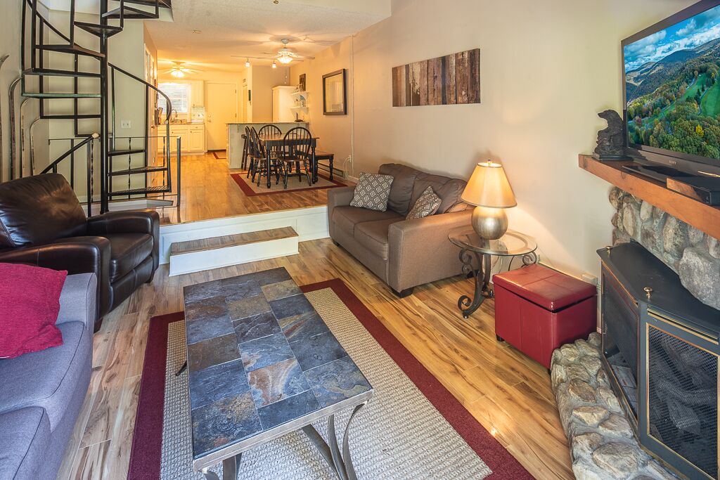 A living room with a fireplace, a sofa, a coffee table, and a TV.
