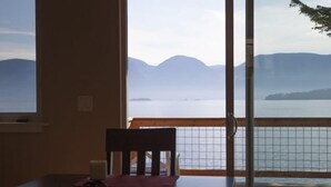 A room with a table and a chair, a window with a view of mountains and water. - Lake House with Sauna, kayaks, S.U.P.'s, snorkeling sets and boat parking (Polson)