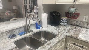 A kitchen with a double sink, a coffee maker, and a coffee shop sign. - Super Clean and Super Comfortable with boat ramp under half mile down the road. (Crystal River)