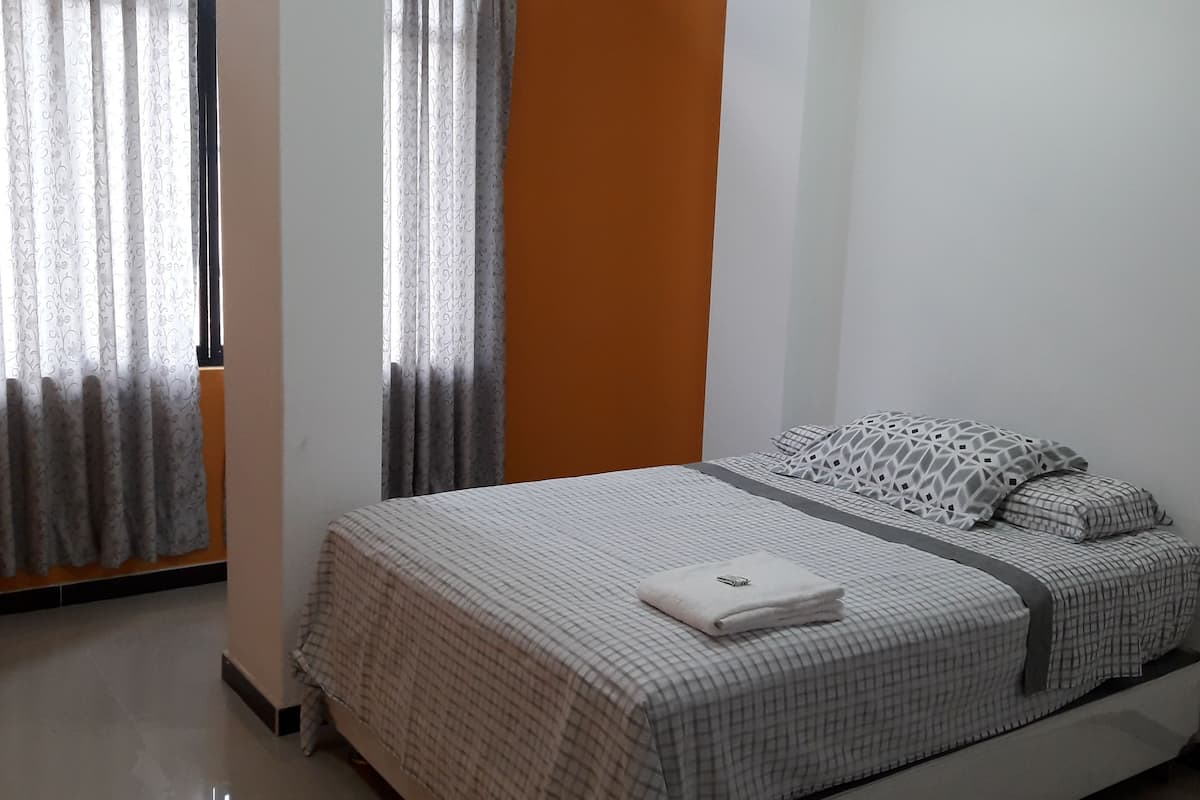 Escritorio, cortinas blackout y tabla de planchar con plancha