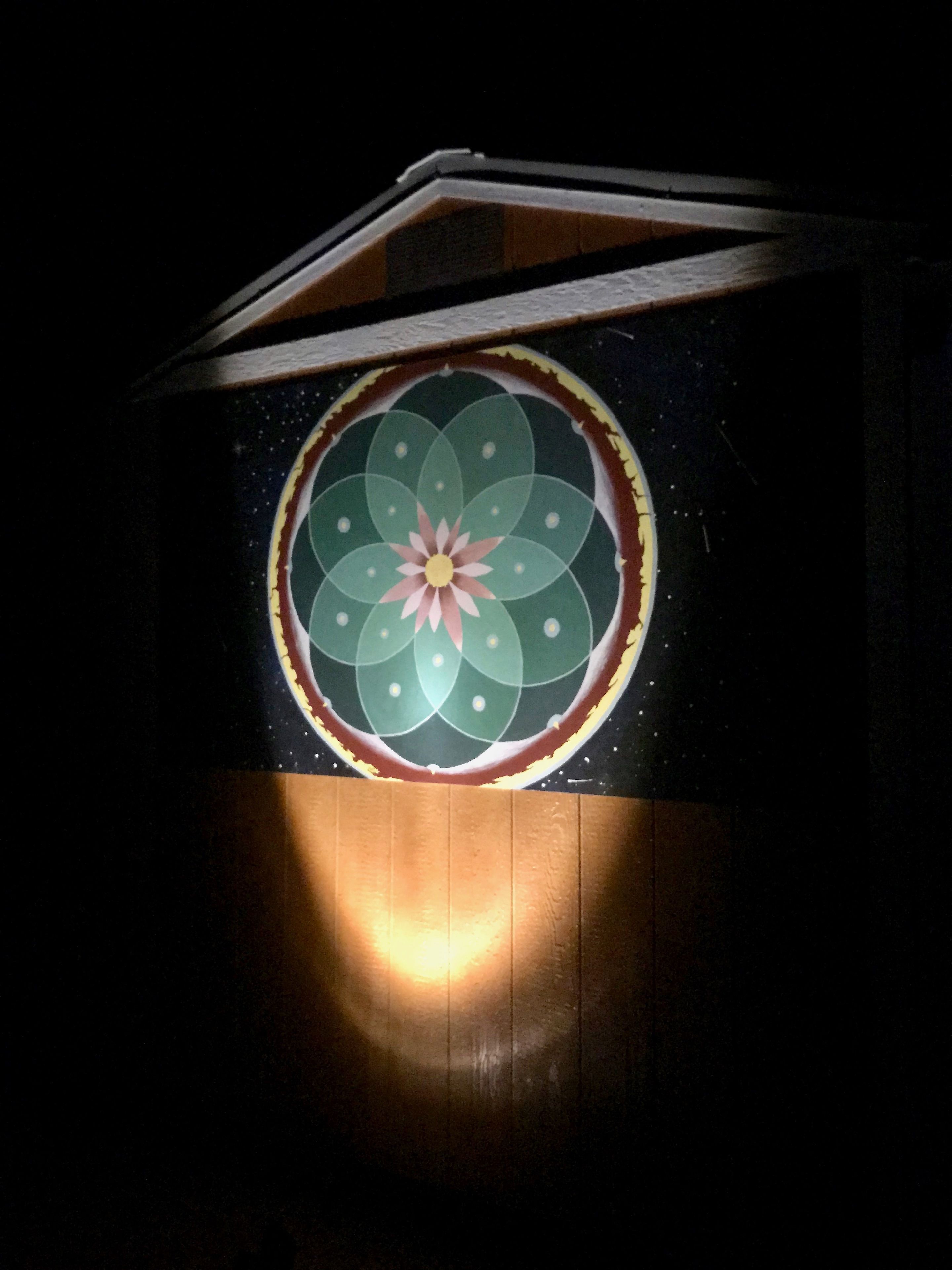 Una habitació amb un mural circular a la paret que representa un disseny floral.
