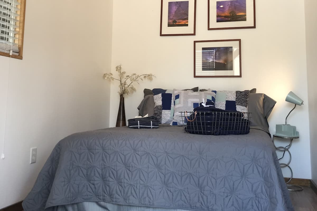 Ein Schlafzimmer mit einem großen Bett, einer Holzbalkendecke und drei gerahmten Bildern an der Wand.