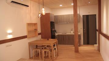 A modern kitchen with wooden cabinets, a dining area with a wooden table and chairs, and a built-in oven.