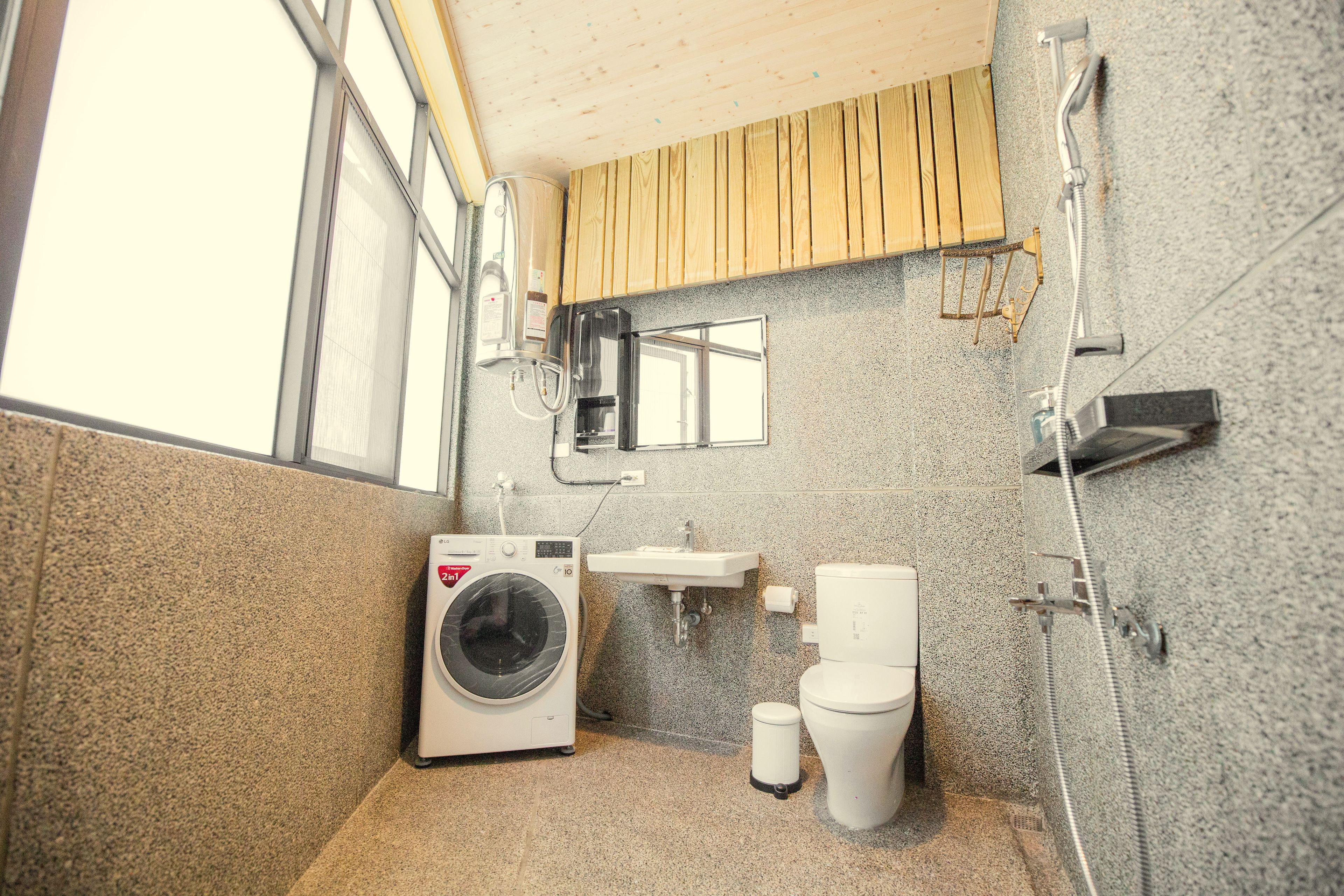 Un baño pequeño con lavadora, inodoro y lavamanos.