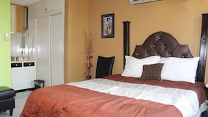 A bedroom with a large bed, a wardrobe, and a small table. - New Kingston Serenity at The Oxford (Kingston)
