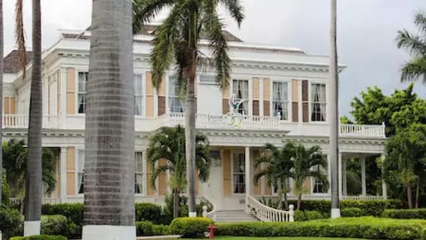 A large, two-story building with a symmetrical facade, a central entrance, and a balcony on the upper floor. - New Kingston Serenity at The Oxford (Kingston)