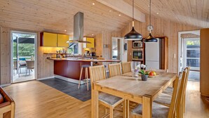 A modern kitchen with wooden cabinetry, a central island, and stainless steel appliances. - Nice home in Ebeltoft with kitchen (Ebeltoft)
